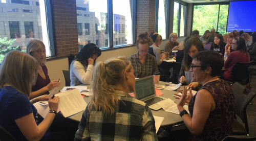 An image of many students collaborating at an English Workshop